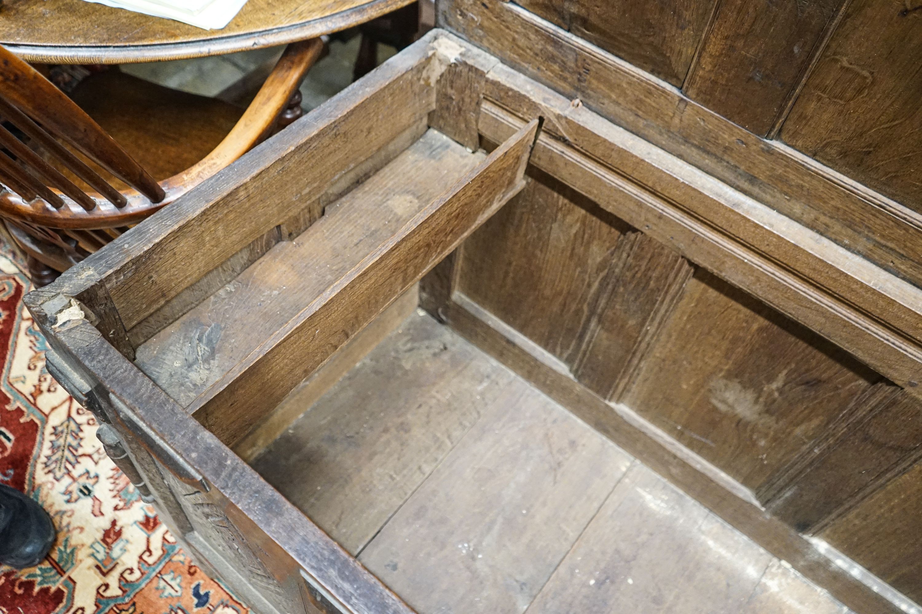 An early 18th century oak coffer, with four panel top and later carved and applied decoration, width 152cm, depth 63cm, height 74cm